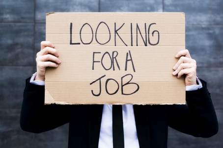 Man holding a sign that says looking for a job