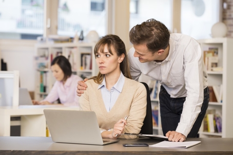 Man touching a women's shoulder at work