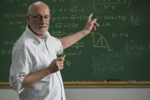 Older male teacher at chalkboard