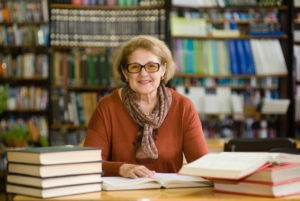 Tenured teacher in library with her books