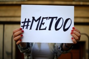 Woman holding up a sign reading #metoo