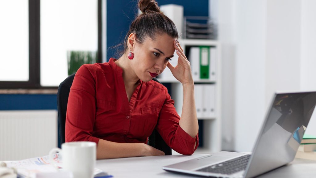 stressed woman looking at computer screen